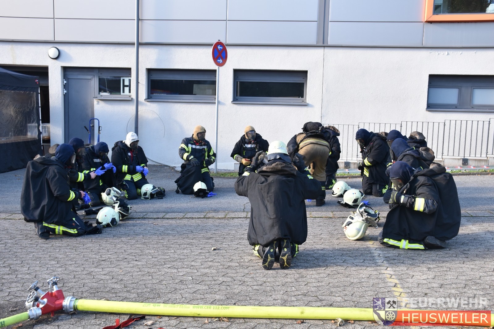 Einsatzkräfte sammeln sich und legen die Schutzausrüstung ab