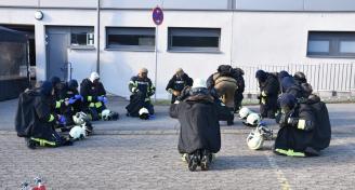 Einsatzkräfte sammeln sich und legen die Schutzausrüstung ab